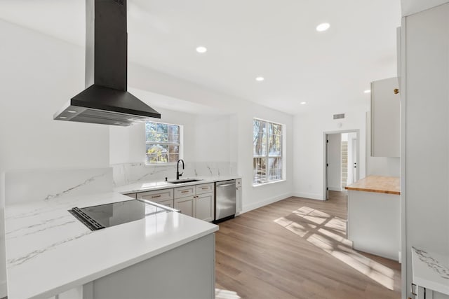 kitchen featuring sink, dishwasher, white cabinetry, island range hood, and kitchen peninsula