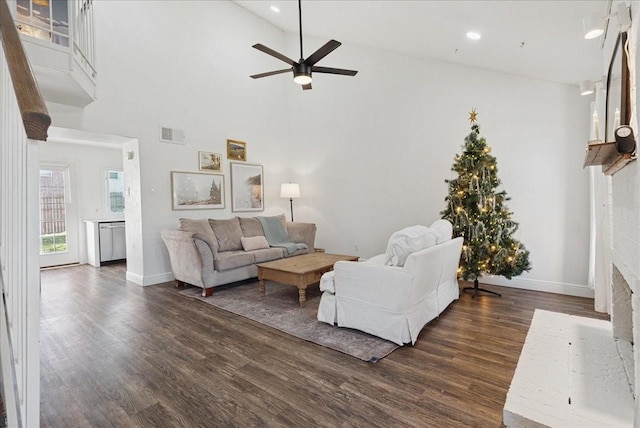 living room featuring ceiling fan, dark wood-type flooring, high vaulted ceiling, and a brick fireplace