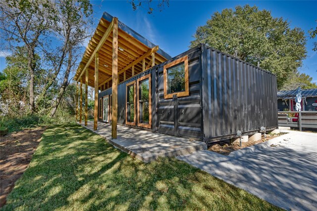 view of side of property with a lawn and an outdoor structure