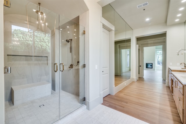 bathroom featuring vanity, hardwood / wood-style flooring, and a shower with shower door