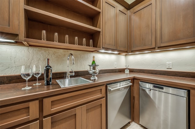 kitchen featuring dishwasher, wood counters, sink, and tasteful backsplash