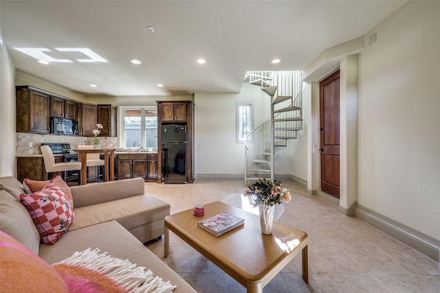 living room featuring sink and light tile patterned flooring