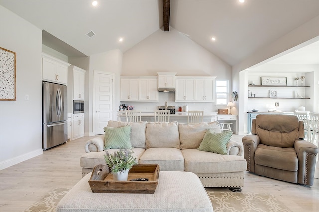 living room with light hardwood / wood-style flooring, beamed ceiling, and high vaulted ceiling