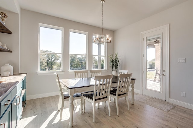 dining area featuring light wood-type flooring and a chandelier