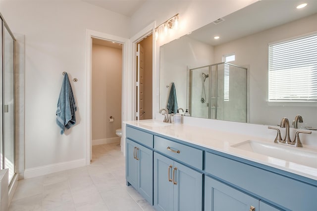 bathroom featuring vanity, toilet, and a shower with shower door