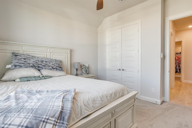 carpeted bedroom featuring ceiling fan, lofted ceiling, and a closet