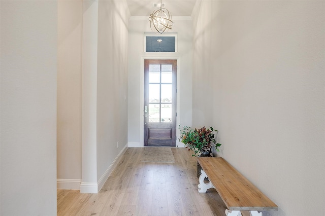 entryway featuring a notable chandelier, light hardwood / wood-style floors, and crown molding