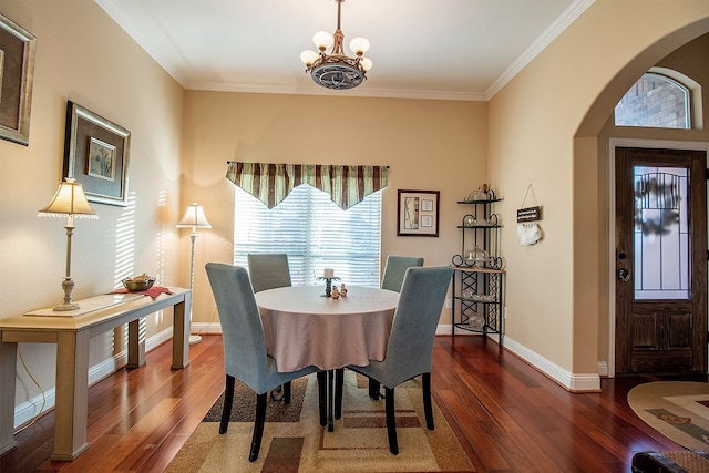 dining space featuring ornamental molding, dark hardwood / wood-style flooring, and a chandelier