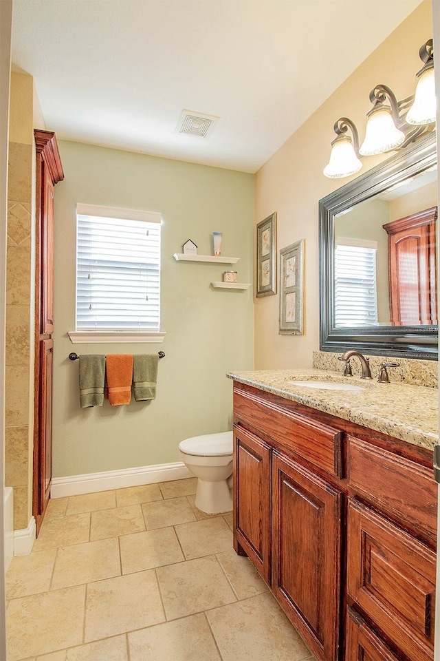 bathroom with toilet, a healthy amount of sunlight, and vanity