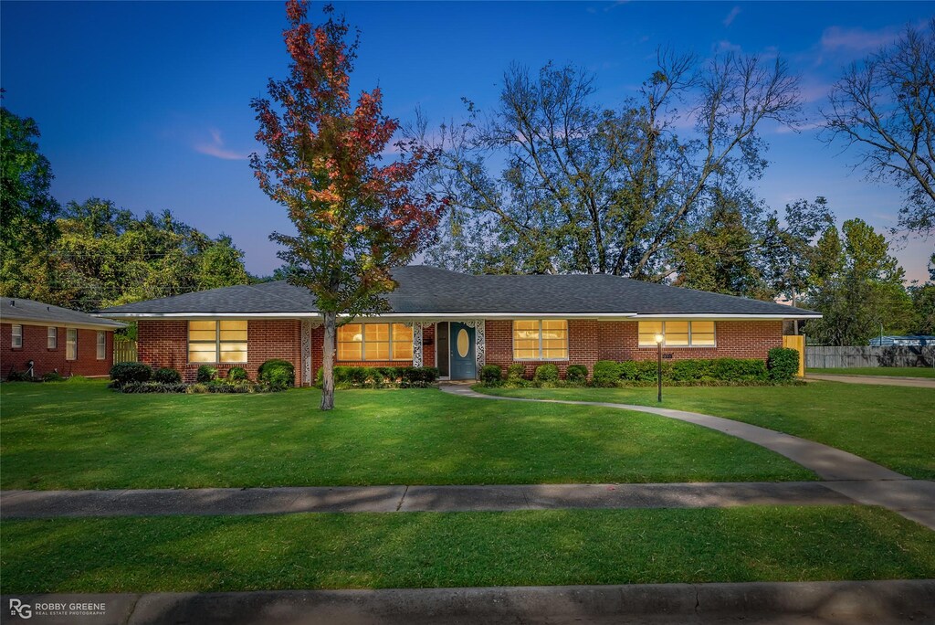 single story home with a lawn