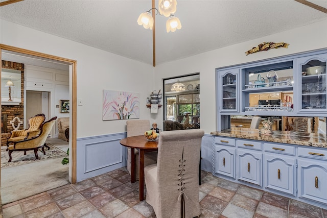 dining area with a textured ceiling and light colored carpet