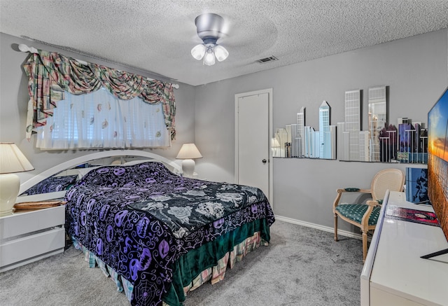 carpeted bedroom featuring ceiling fan and a textured ceiling