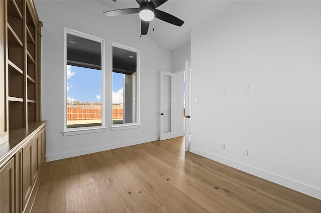 spare room featuring light hardwood / wood-style flooring, vaulted ceiling, and ceiling fan