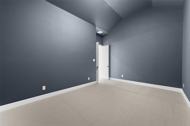 empty room featuring light colored carpet and lofted ceiling