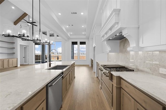 kitchen featuring light stone countertops, sink, stainless steel appliances, an inviting chandelier, and decorative light fixtures