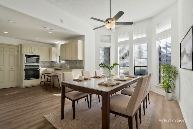 dining area featuring a textured ceiling, light hardwood / wood-style floors, ceiling fan, and sink