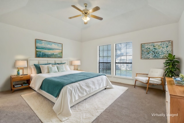 bedroom featuring light carpet, a tray ceiling, and ceiling fan