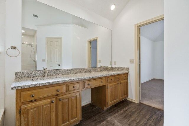 bathroom with vanity, wood-type flooring, walk in shower, and vaulted ceiling