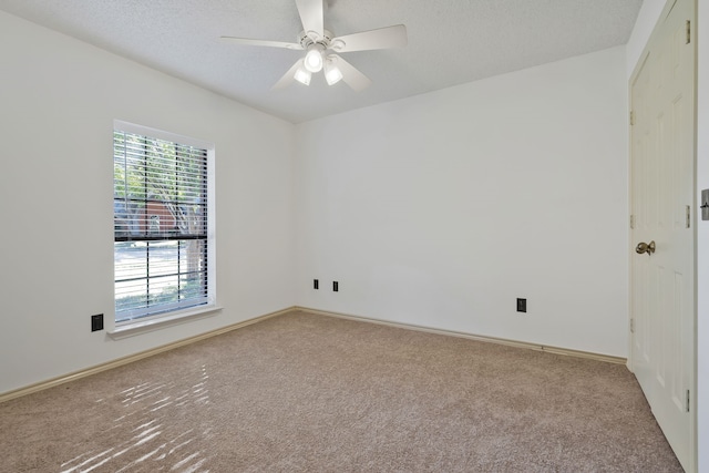 empty room featuring a textured ceiling, carpet floors, and ceiling fan