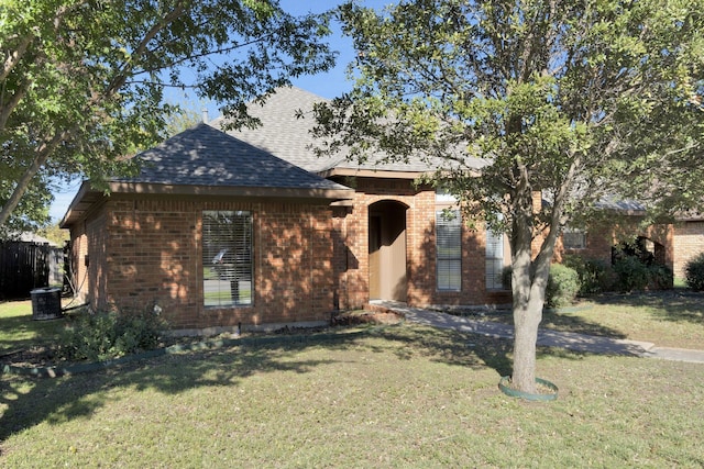 view of front of house with central AC and a front lawn