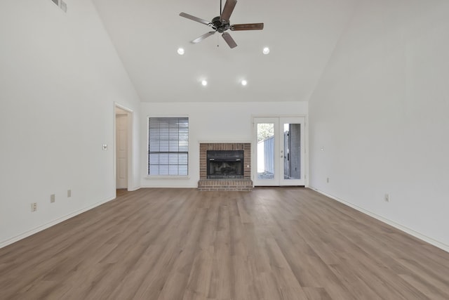 unfurnished living room featuring ceiling fan, french doors, high vaulted ceiling, and light wood-type flooring