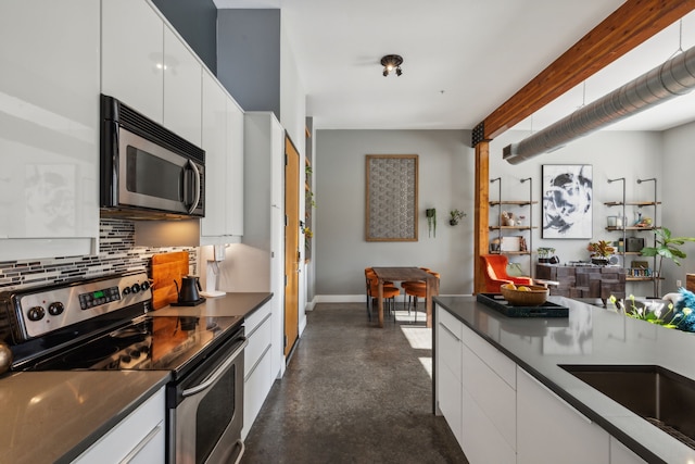 kitchen featuring white cabinets, decorative backsplash, and stainless steel appliances