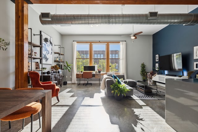 living room with ceiling fan and concrete floors