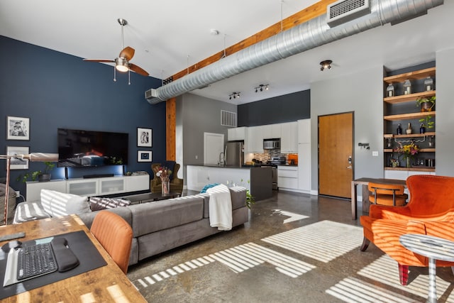 living room featuring ceiling fan and a towering ceiling