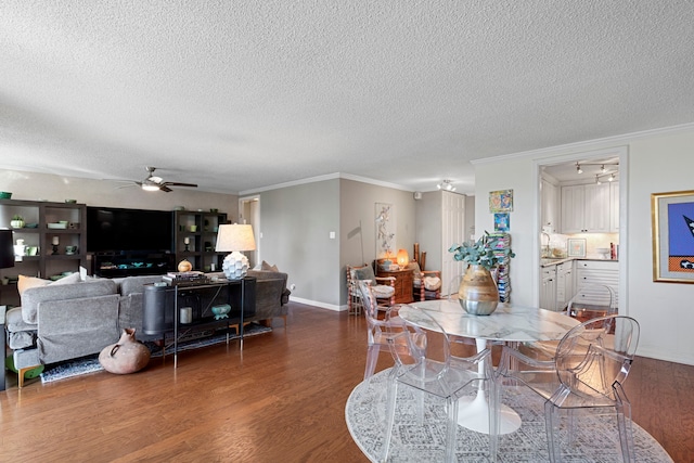 dining area featuring crown molding, ceiling fan, dark wood-type flooring, and a textured ceiling