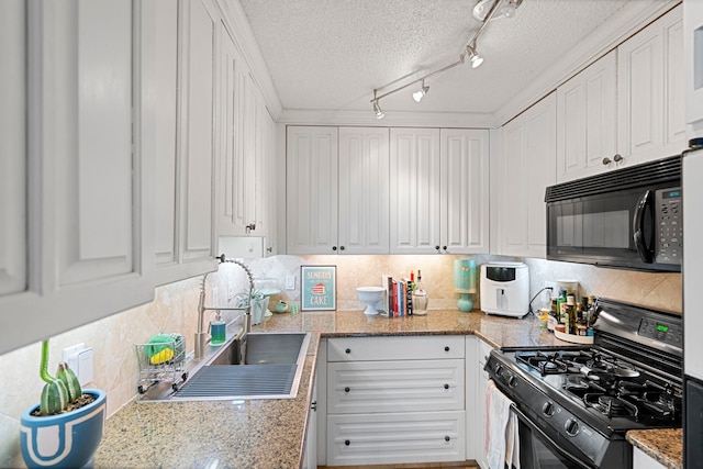 kitchen featuring gas range oven, a textured ceiling, white cabinets, and sink