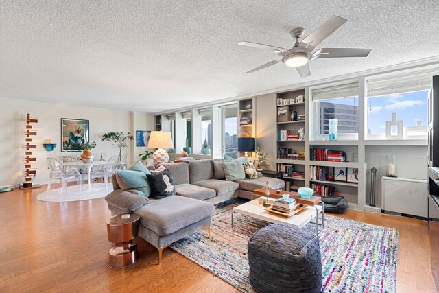 living room featuring a textured ceiling, hardwood / wood-style flooring, and ceiling fan