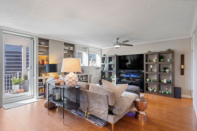 living room featuring a textured ceiling, light hardwood / wood-style flooring, ceiling fan, and ornamental molding