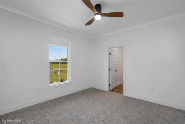 empty room featuring dark carpet, ceiling fan, and ornamental molding