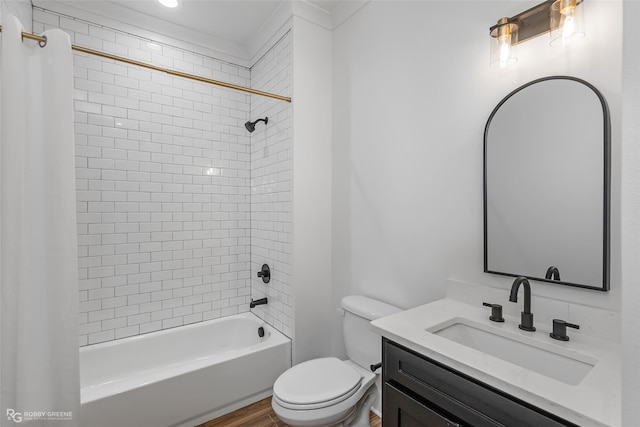 full bathroom featuring hardwood / wood-style flooring, tiled shower / bath combo, toilet, and vanity