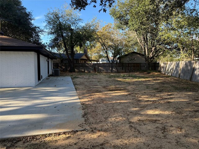 view of yard featuring central AC unit and a patio area