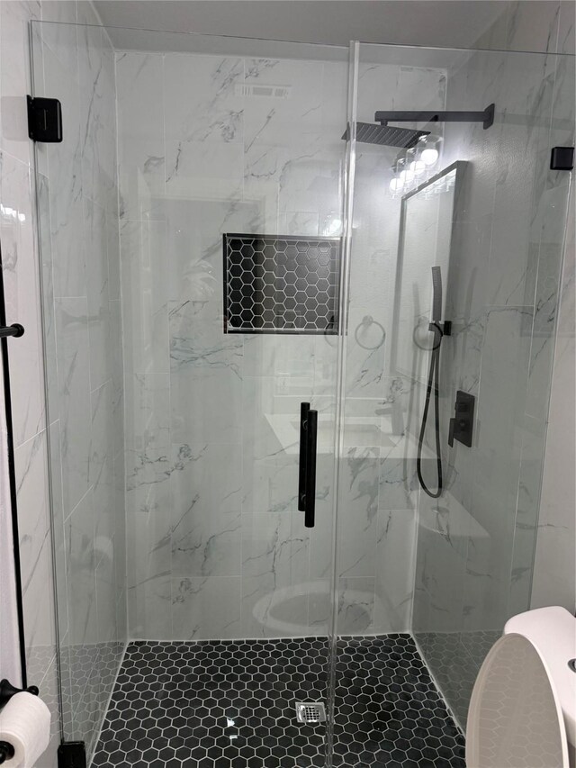 bathroom with toilet and a shower with shower door