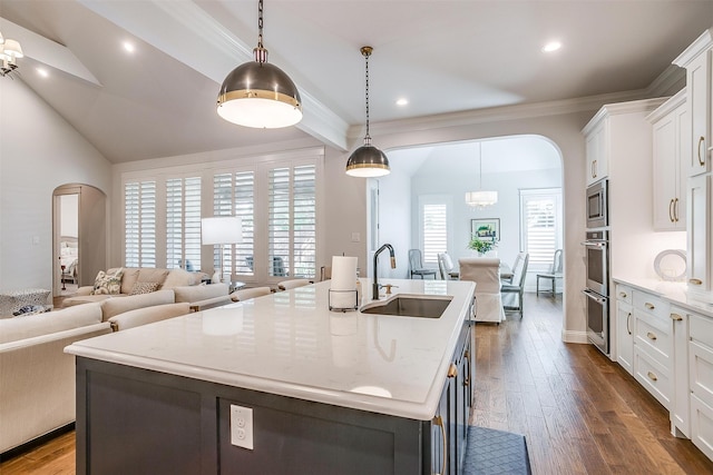 kitchen with sink, dark hardwood / wood-style flooring, pendant lighting, a kitchen island with sink, and white cabinets