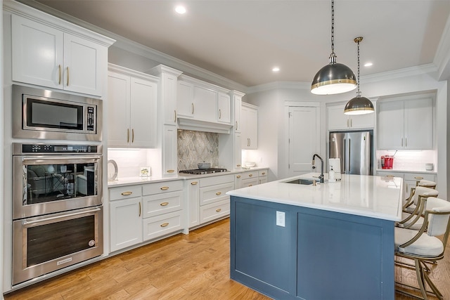 kitchen featuring white cabinetry, pendant lighting, stainless steel appliances, and sink