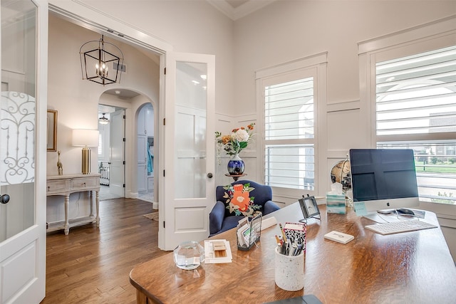 office space with crown molding, hardwood / wood-style floors, and a notable chandelier