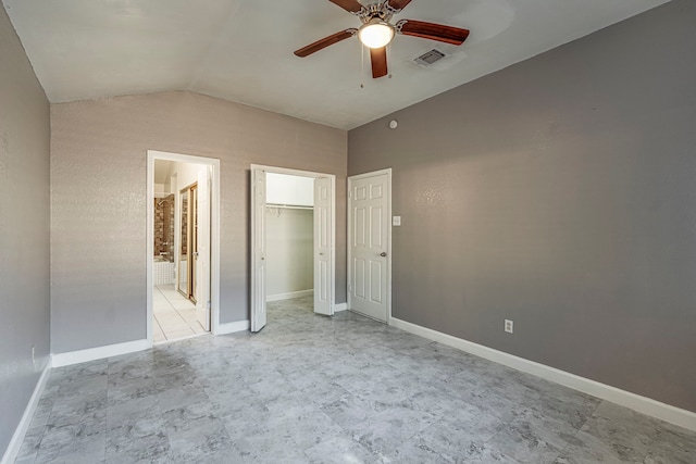 unfurnished bedroom featuring ensuite bath, ceiling fan, and lofted ceiling