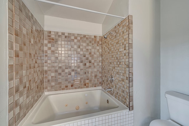 bathroom with tiled shower / bath combo and toilet