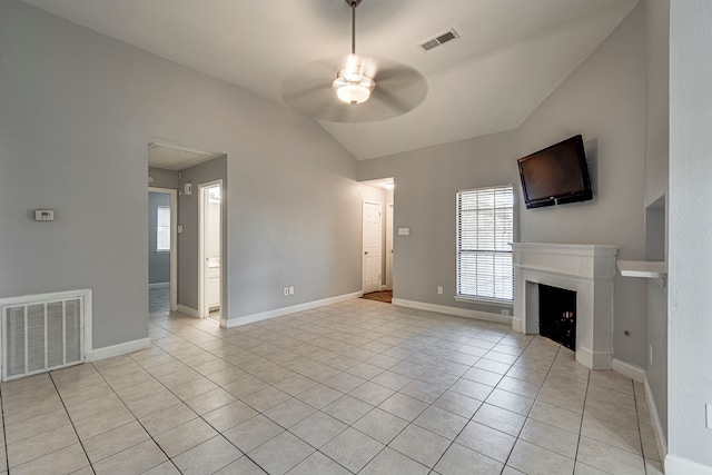 unfurnished living room with vaulted ceiling, ceiling fan, and light tile patterned flooring