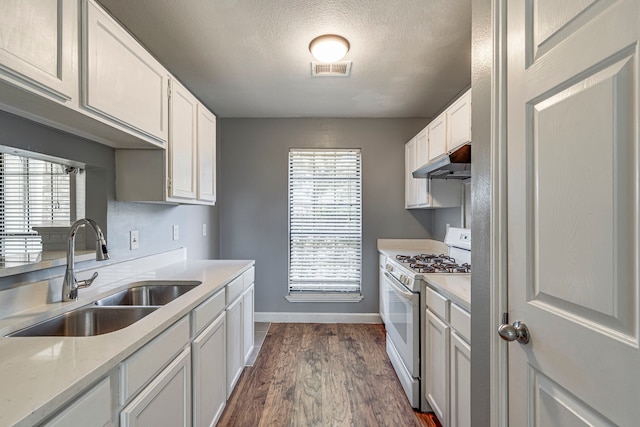 kitchen with a textured ceiling, dark wood-type flooring, sink, white cabinets, and white gas stove