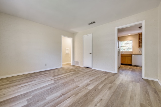 spare room featuring light wood-type flooring and sink