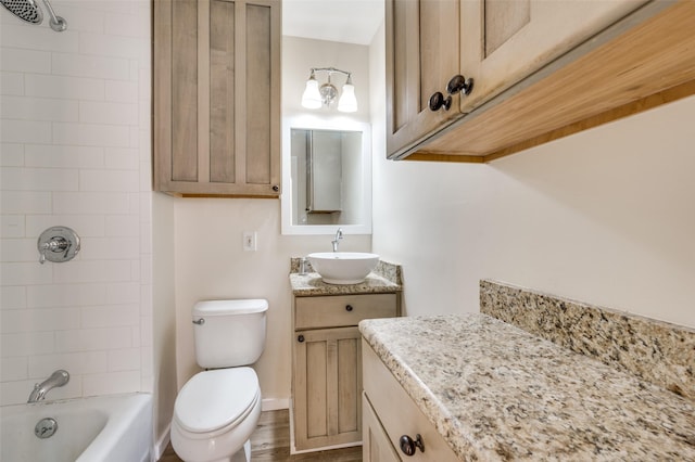 full bathroom with wood-type flooring, vanity, toilet, and tiled shower / bath combo