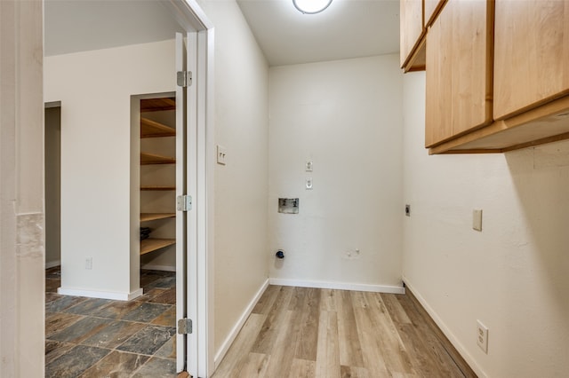 laundry area featuring electric dryer hookup, cabinets, wood-type flooring, and washer hookup