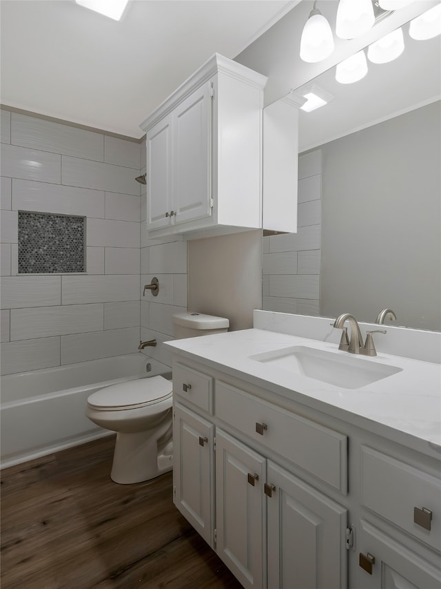 full bathroom featuring vanity, toilet, wood-type flooring, and tiled shower / bath