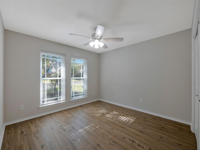 empty room with ceiling fan and wood-type flooring