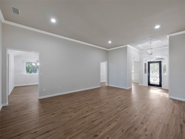 unfurnished living room with ornamental molding, dark hardwood / wood-style floors, and an inviting chandelier