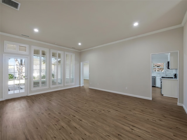 unfurnished living room with dark hardwood / wood-style flooring and ornamental molding